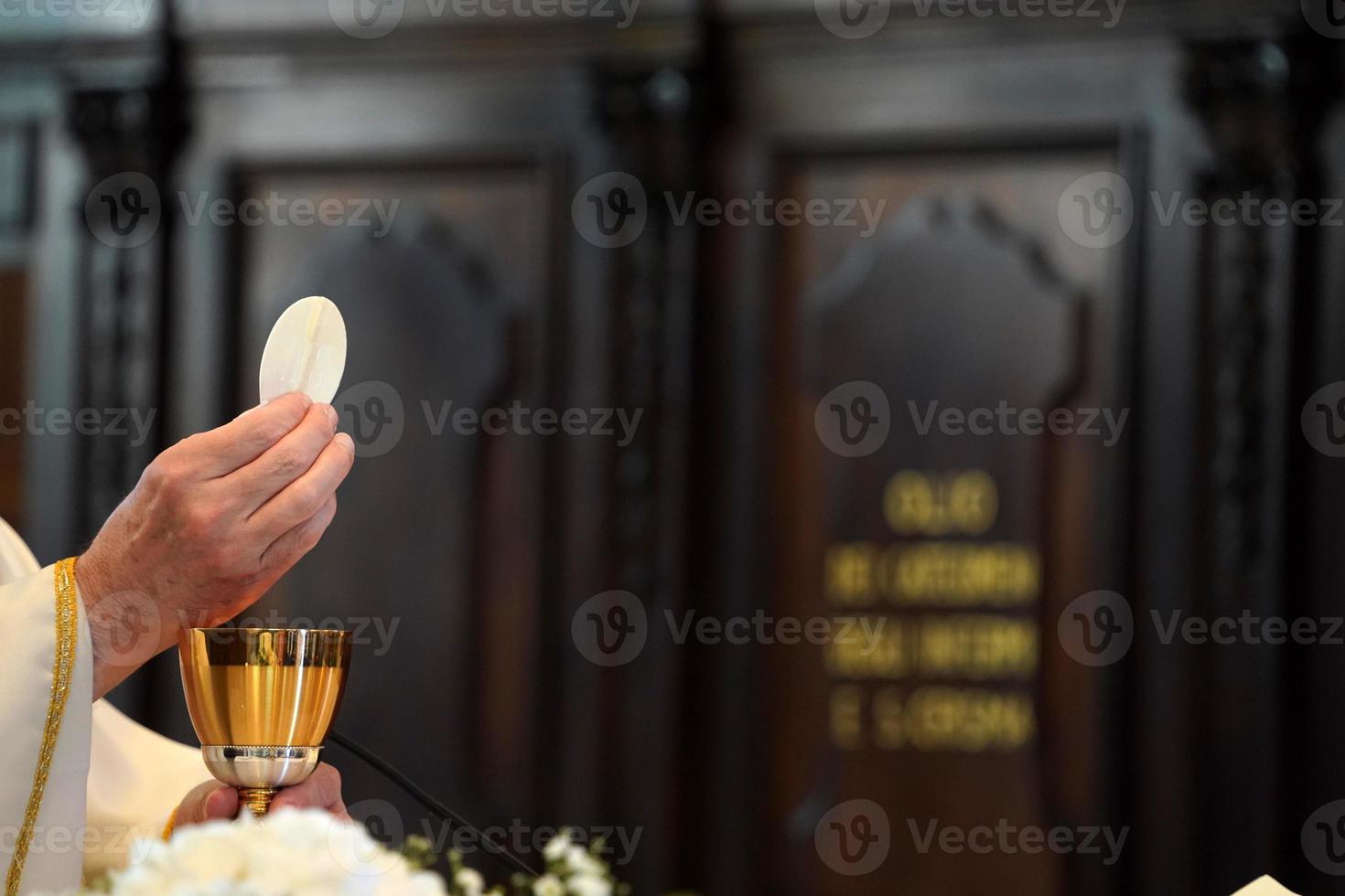 padre mostrando a hóstia durante a missa foto