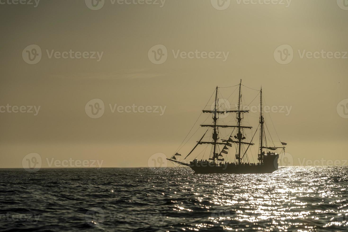silhueta de navio pirata ao pôr do sol foto