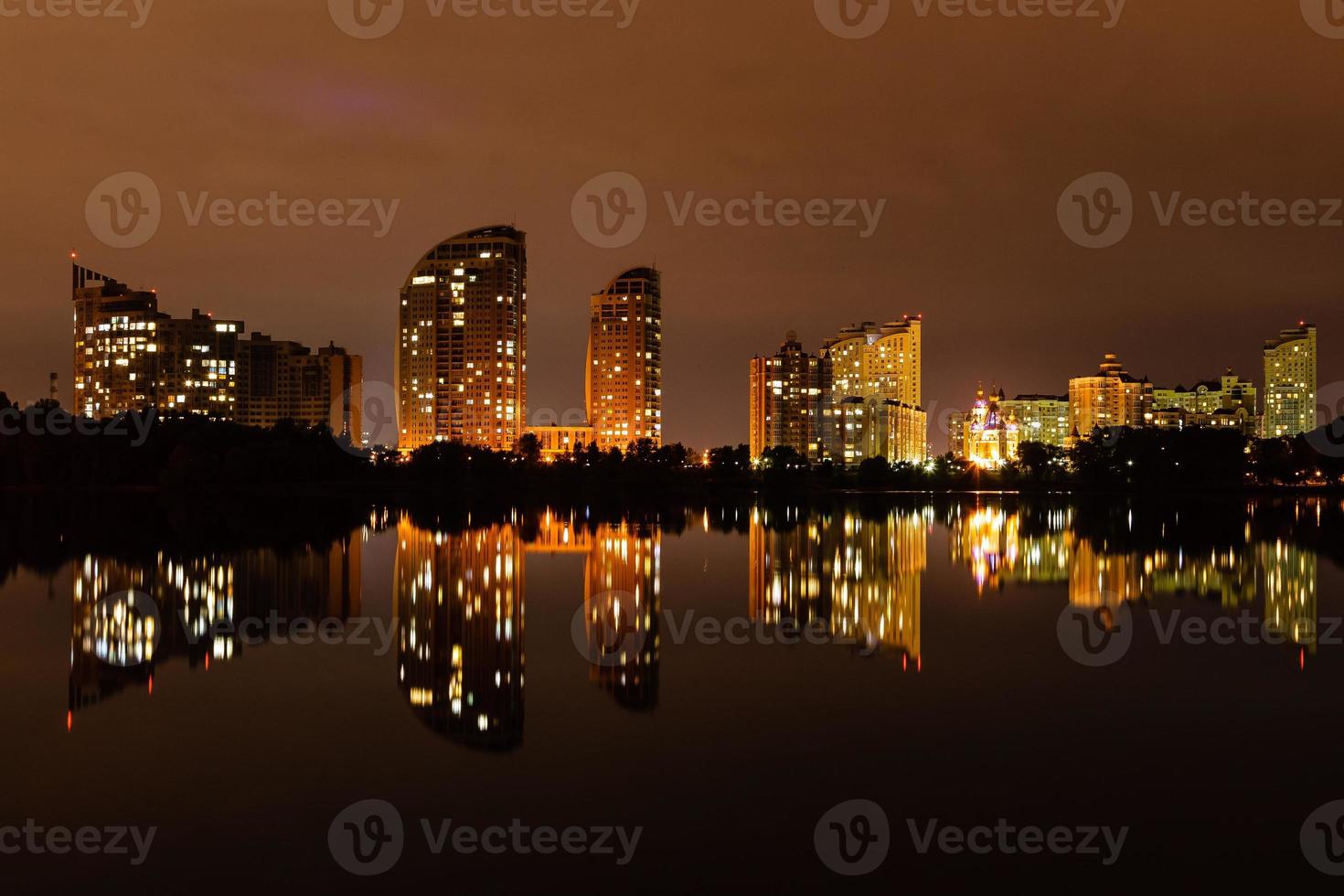 cidade noturna com reflexo de casas no rio foto