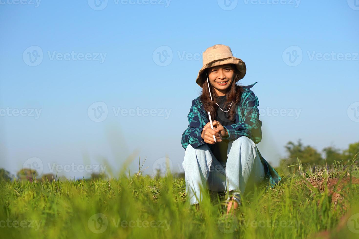 agricultoras asiáticas usam computadores para analisar o crescimento das plantas de arroz. foto