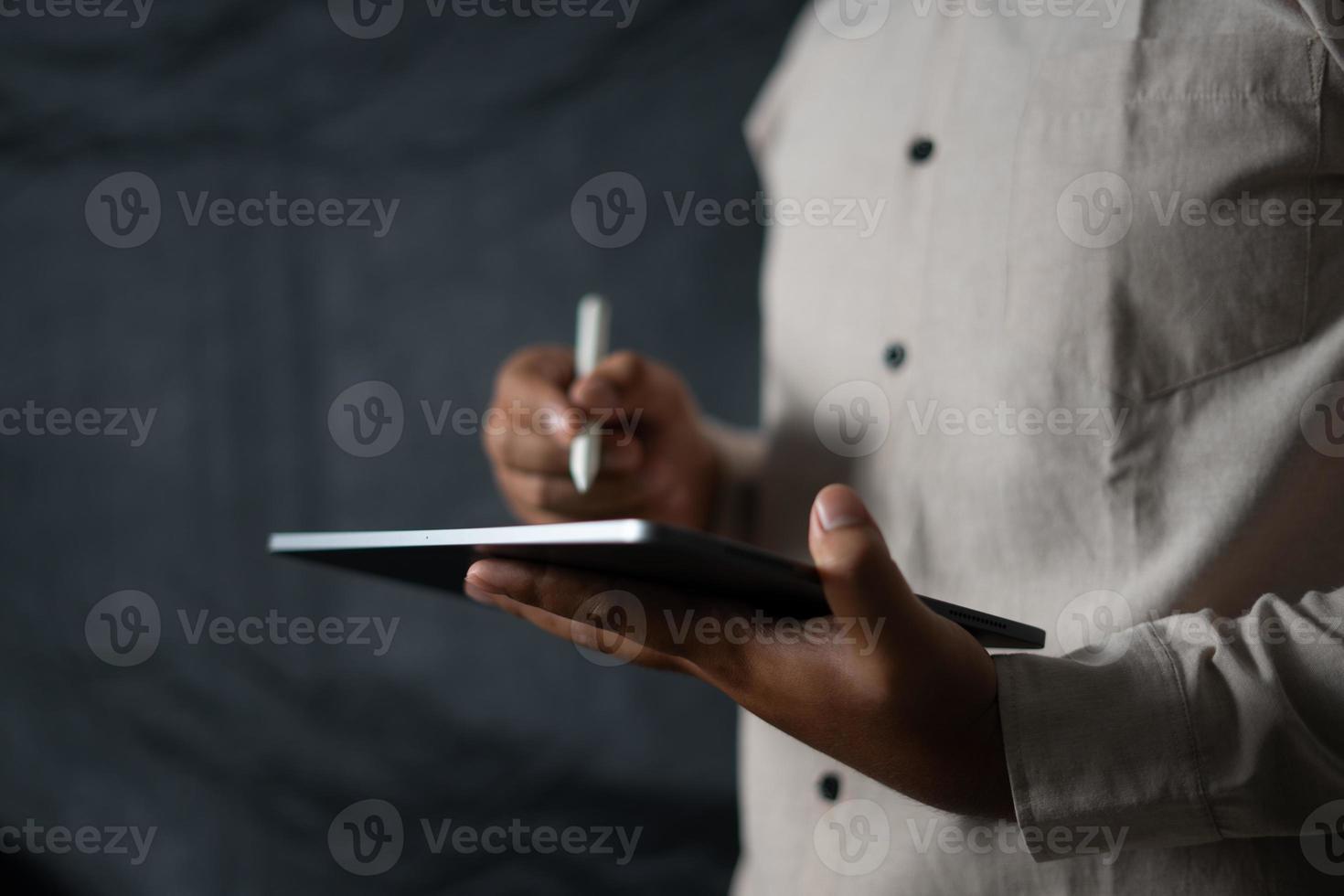 mão segurando o tablet e caneta para monitorar negócios foto