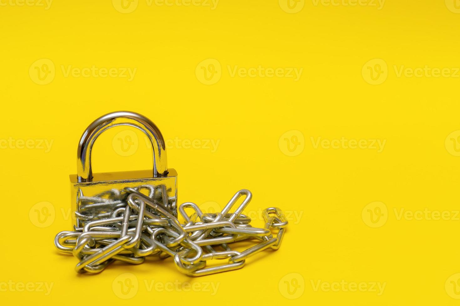 cadeado fechado com corrente em fundo amarelo com espaço de cópia, proibição, tabu foto