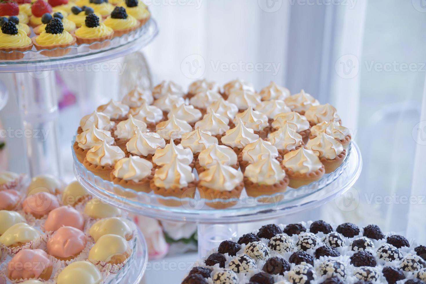 doces e biscoitos dispostos na mesa para festa de casamento foto