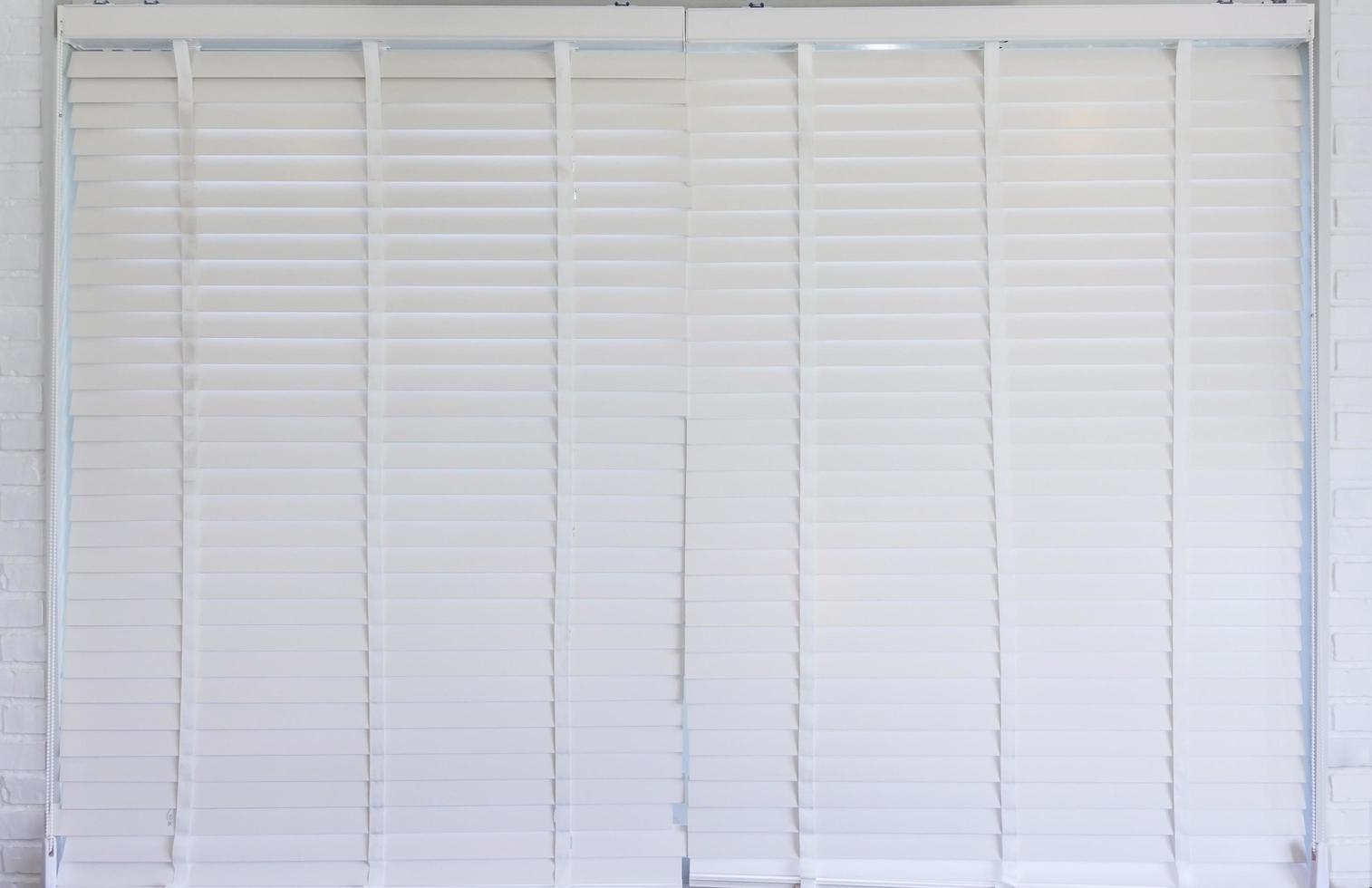 veneziana de proteção solar de cor branca na janela em um dia ensolarado foto