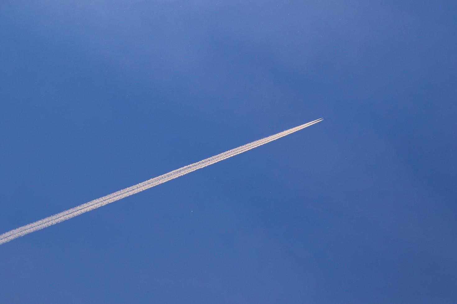 um avião e trilhas de vapor no céu foto
