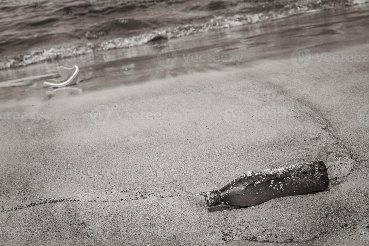 garrafa de plástico encalhada lavada com poluição de lixo na praia brasil. foto