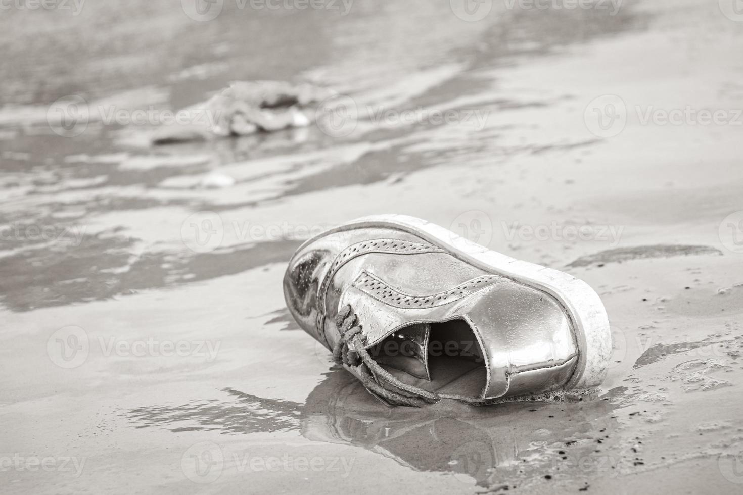 sapato dourado encalhado lavado com poluição de lixo na praia brasil. foto
