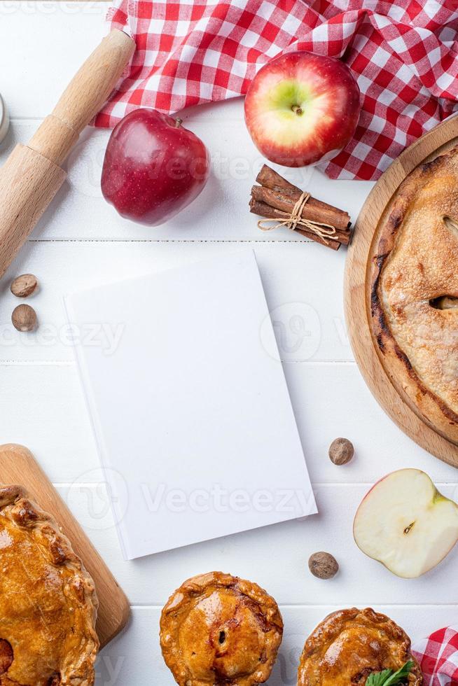 maquete de capa de livro de culinária em branco com torta de maçã, torta de carne e frutas da estação foto