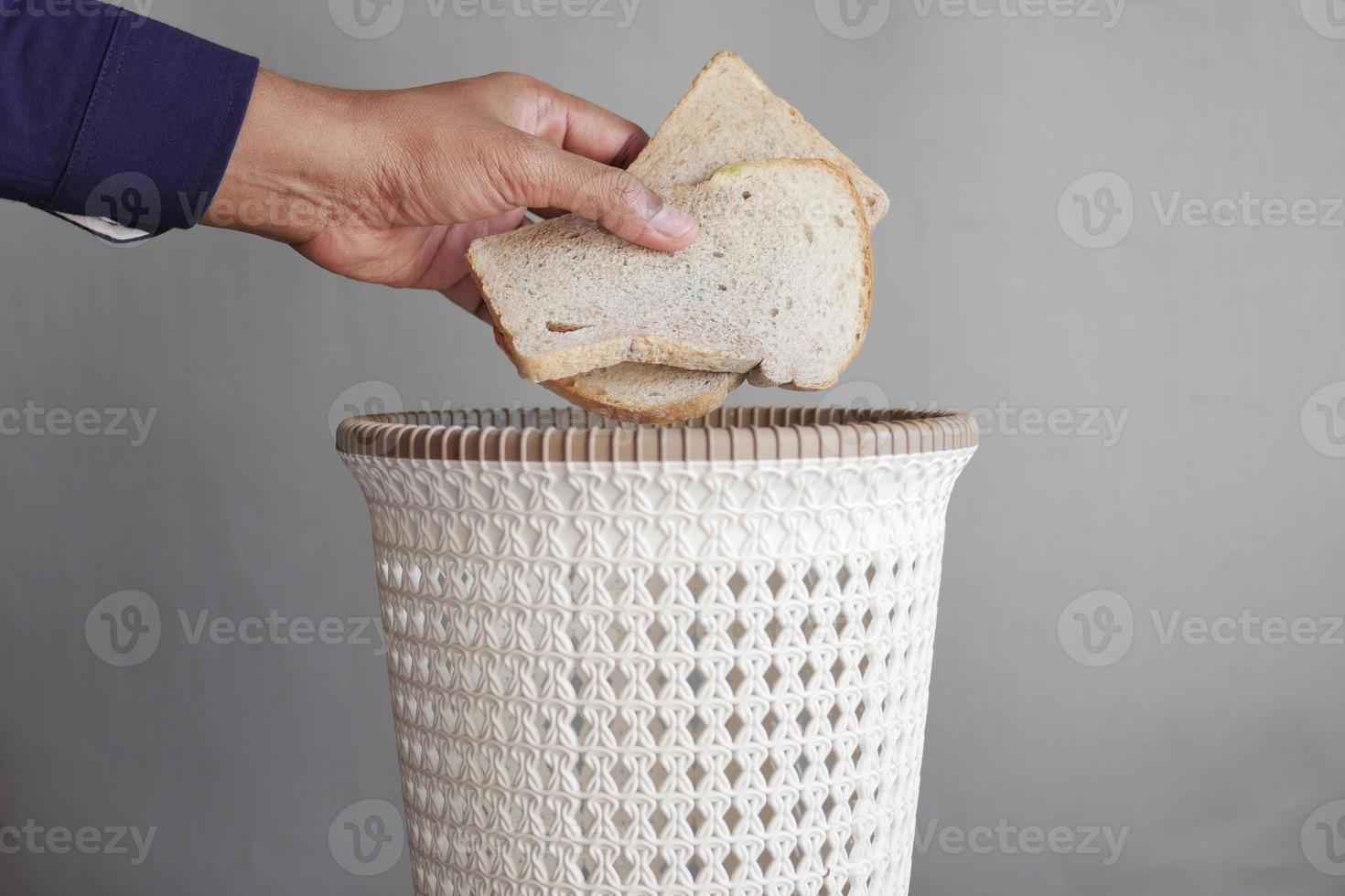 jogando pão velho no lixo foto