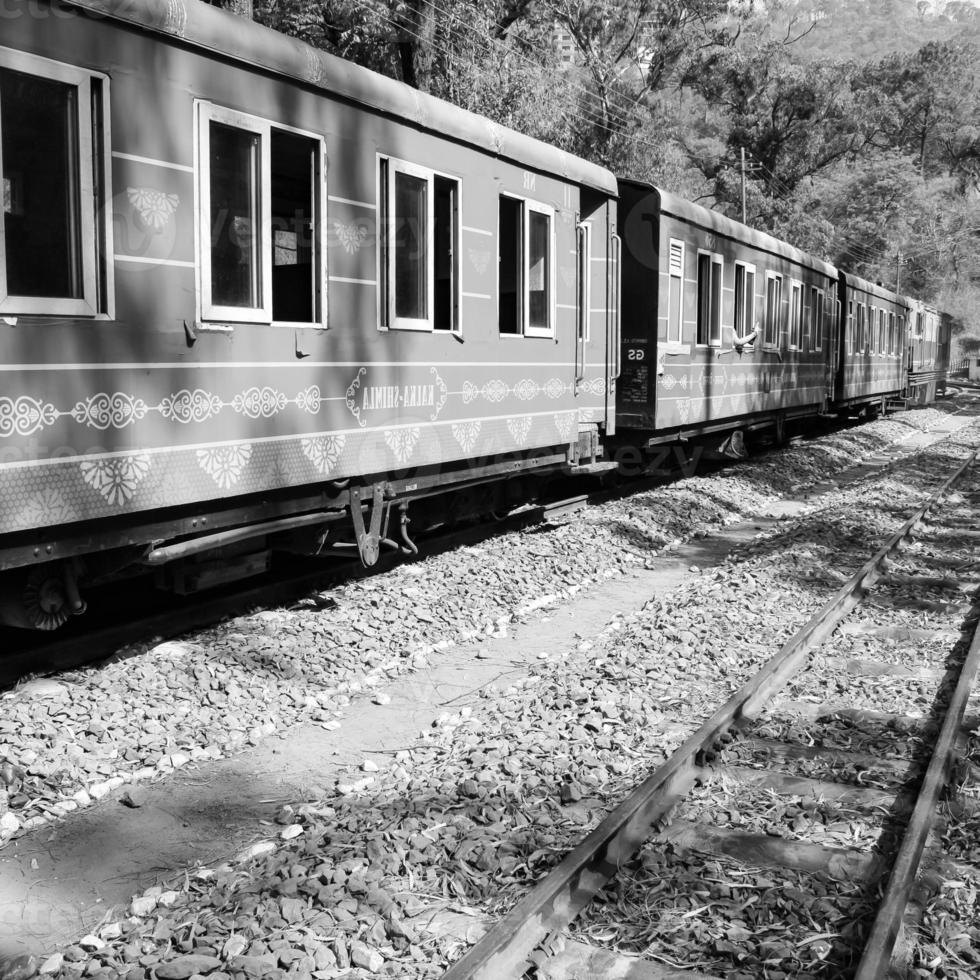 trem de brinquedo movendo-se na encosta da montanha, bela vista, uma montanha lateral, um vale lateral movendo-se na ferrovia para a colina, entre a floresta natural verde. trem de brinquedo de kalka para shimla na índia foto