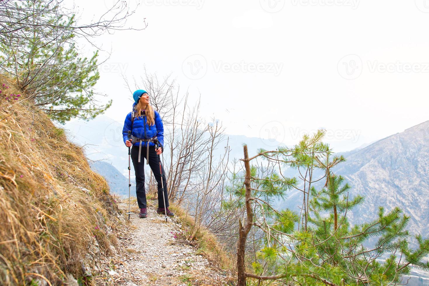 menina olha a vista durante uma caminhada em uma trilha de montanha foto