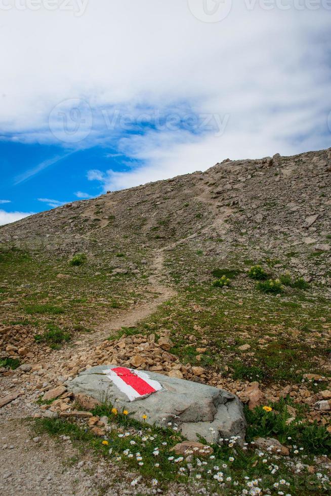 marca vermelha na rocha para trilha de montanha foto