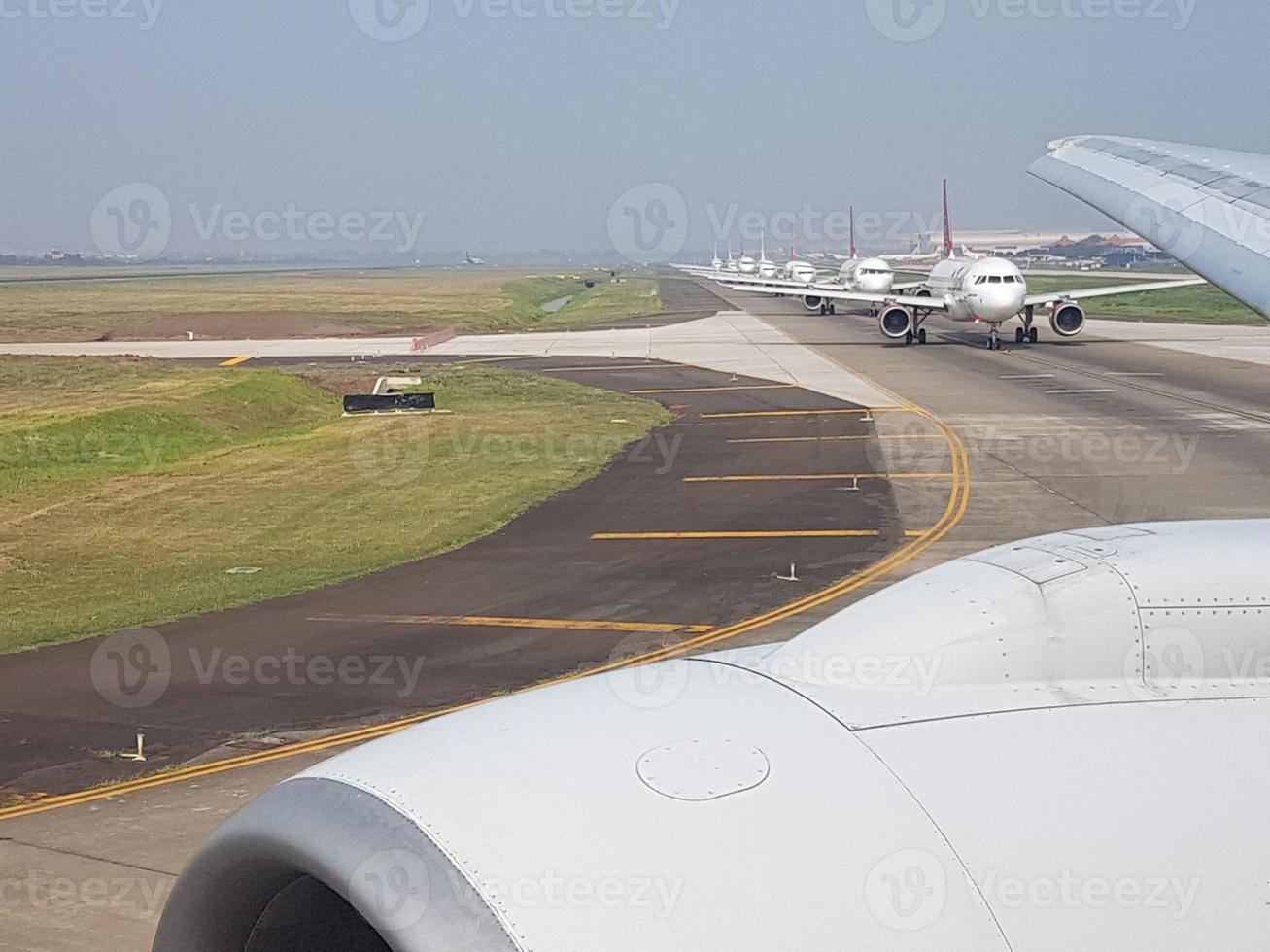 imagem de vários aviões em uma pista de aeroporto esperando a autorização de decolagem foto