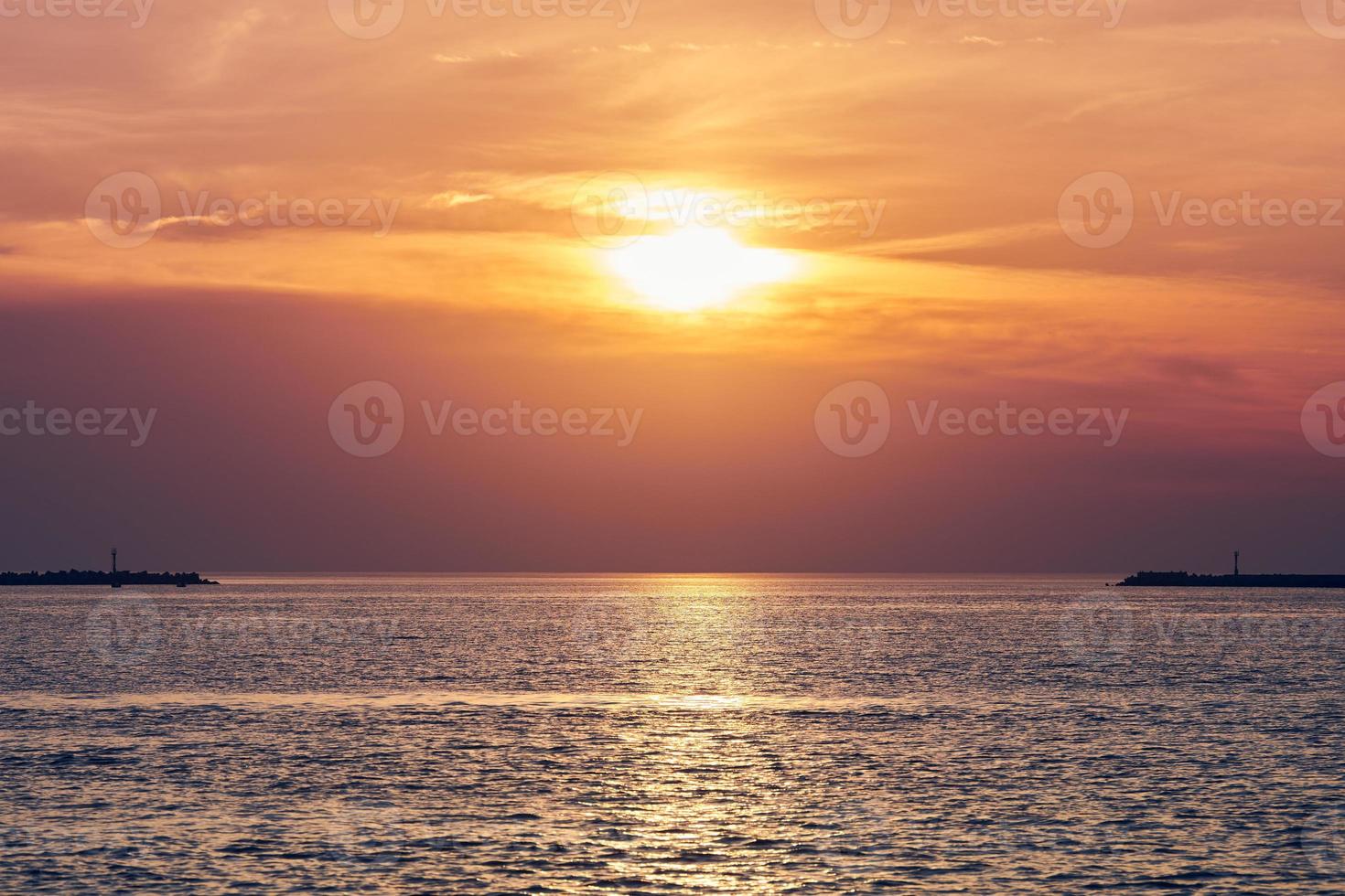 mar calmo com céu pôr do sol, bela vista panorâmica, incrível sol nascente dramático refletido na água foto