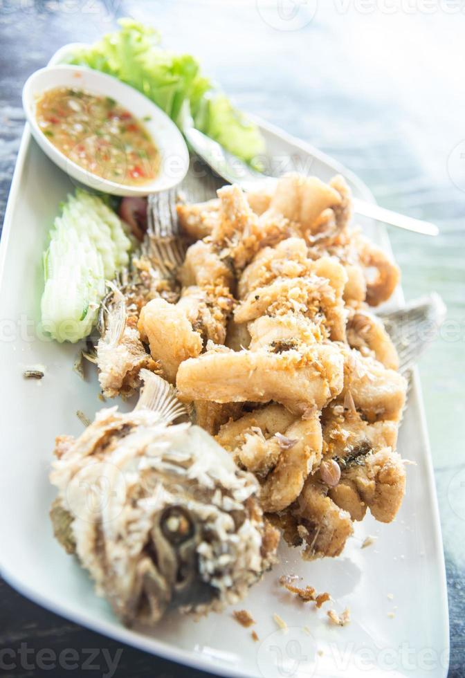 peixe gourami gigante frito com molho de alho e frutos do mar, província de uthai thani, tailândia foto