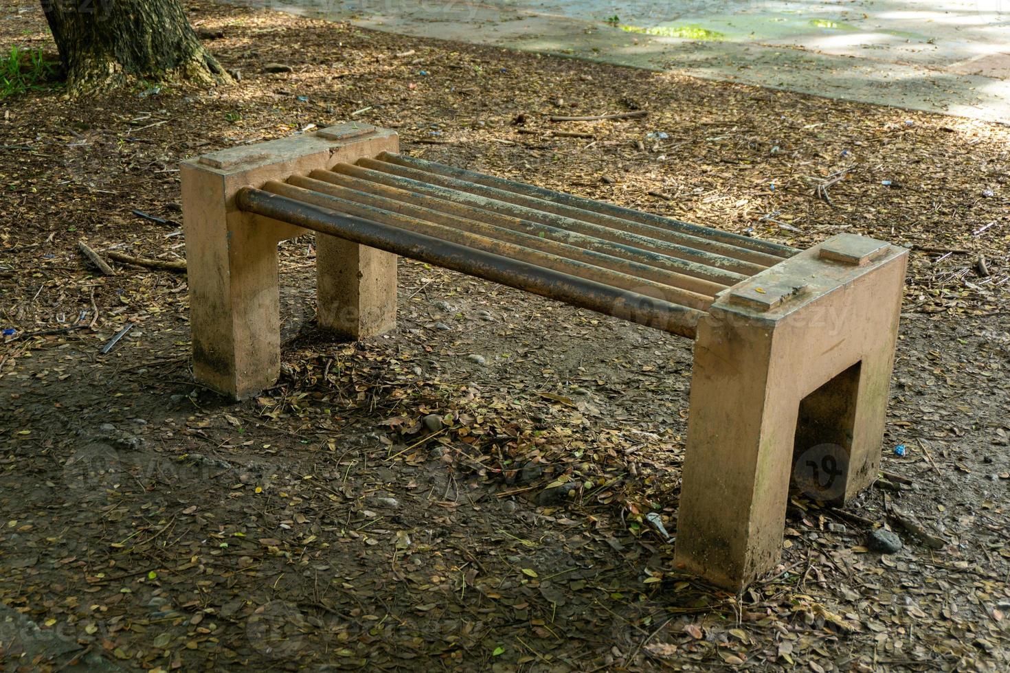 banco de concreto no parque da cidade. banco de cimento ao ar livre. cadeira feita de cimento no jardim foto