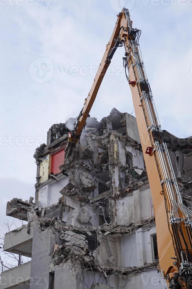 edifício de vários andares demolido e desmontado por máquina foto