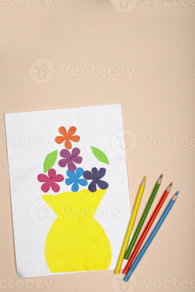 artesanato de papel para crianças. aplicação da criatividade das crianças. jardim de infância e escola de artesanato. sobre um fundo bege, um vaso e flores de papel colorido. foto