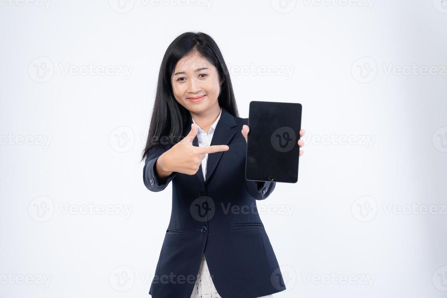 retrato de mulher corporativa lê notícias, trabalha em seu tablet digital a caminho do escritório, retrato de mulher de negócios, segurando um tablet na mão foto