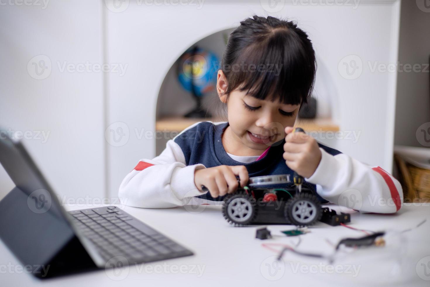 estudantes da ásia aprendem em casa na codificação de carros robôs e cabos de placa eletrônica em haste, vapor, matemática, engenharia, ciência, tecnologia, código de computador em robótica para o conceito de crianças foto