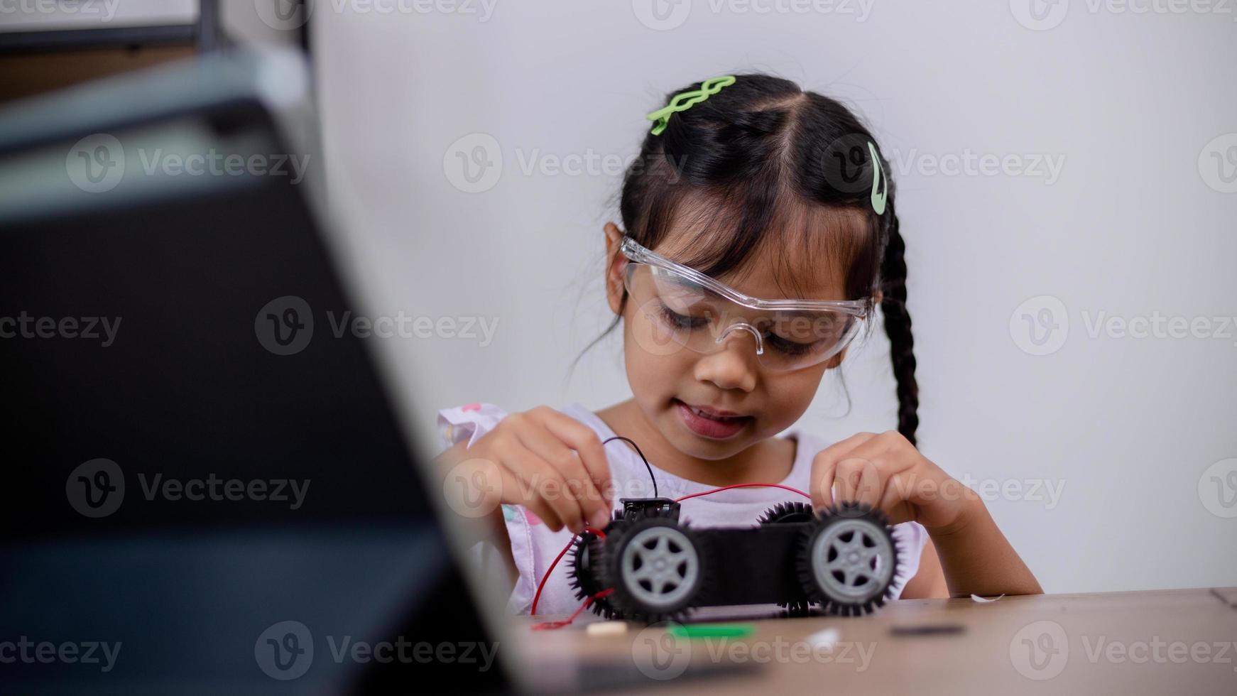 estudantes asiáticos aprendem em casa codificando carros robôs e cabos de placas eletrônicas em haste, vapor, matemática engenharia ciência tecnologia código de computador em robótica para conceitos infantis. foto