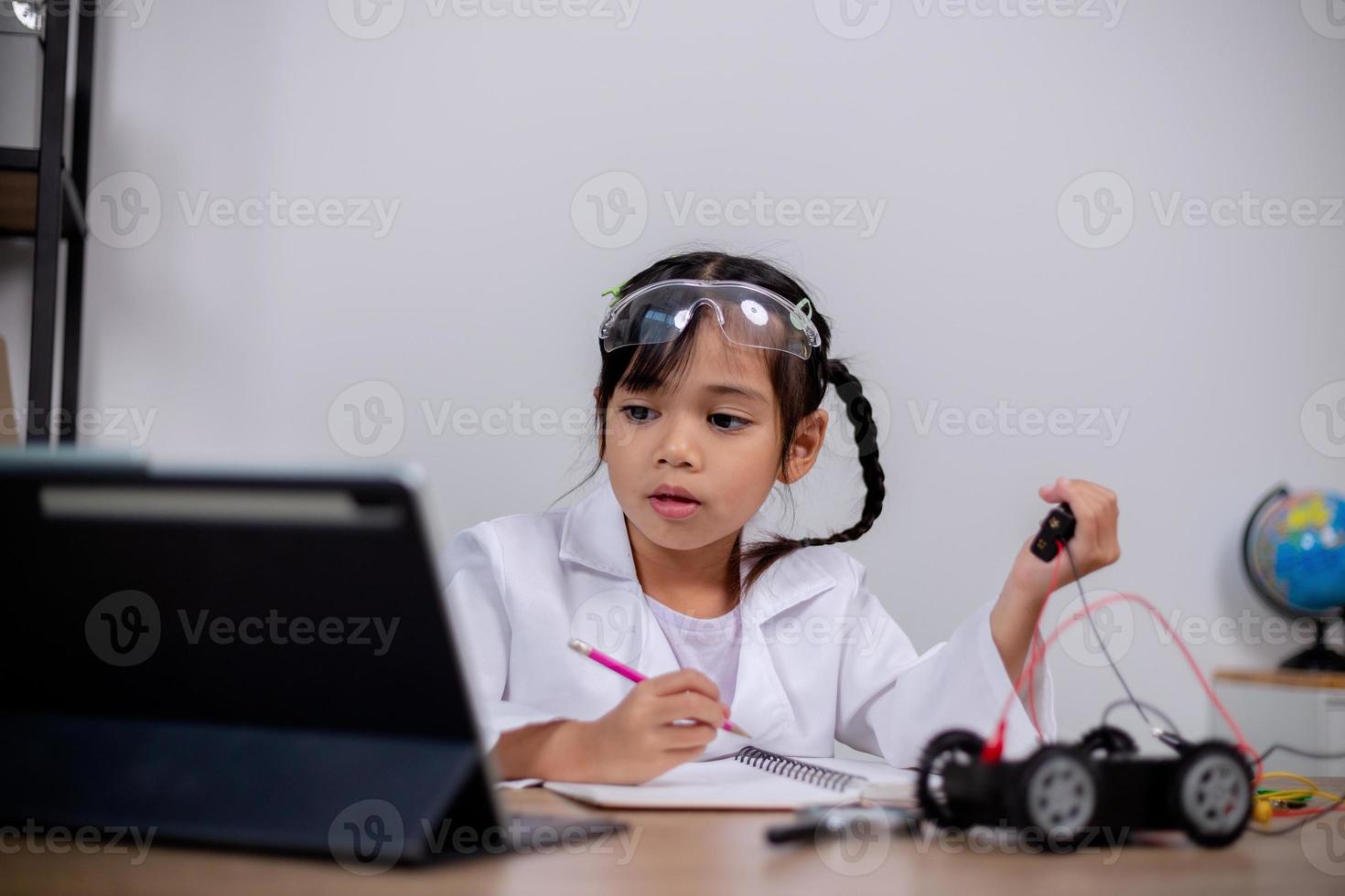 estudantes asiáticos aprendem em casa codificando carros robôs e cabos de placas eletrônicas em haste, vapor, matemática engenharia ciência tecnologia código de computador em robótica para conceitos infantis. foto