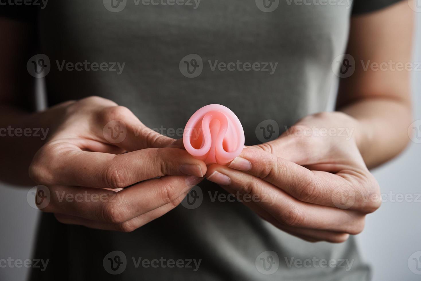 mulher segura copo menstrual nas mãos foto