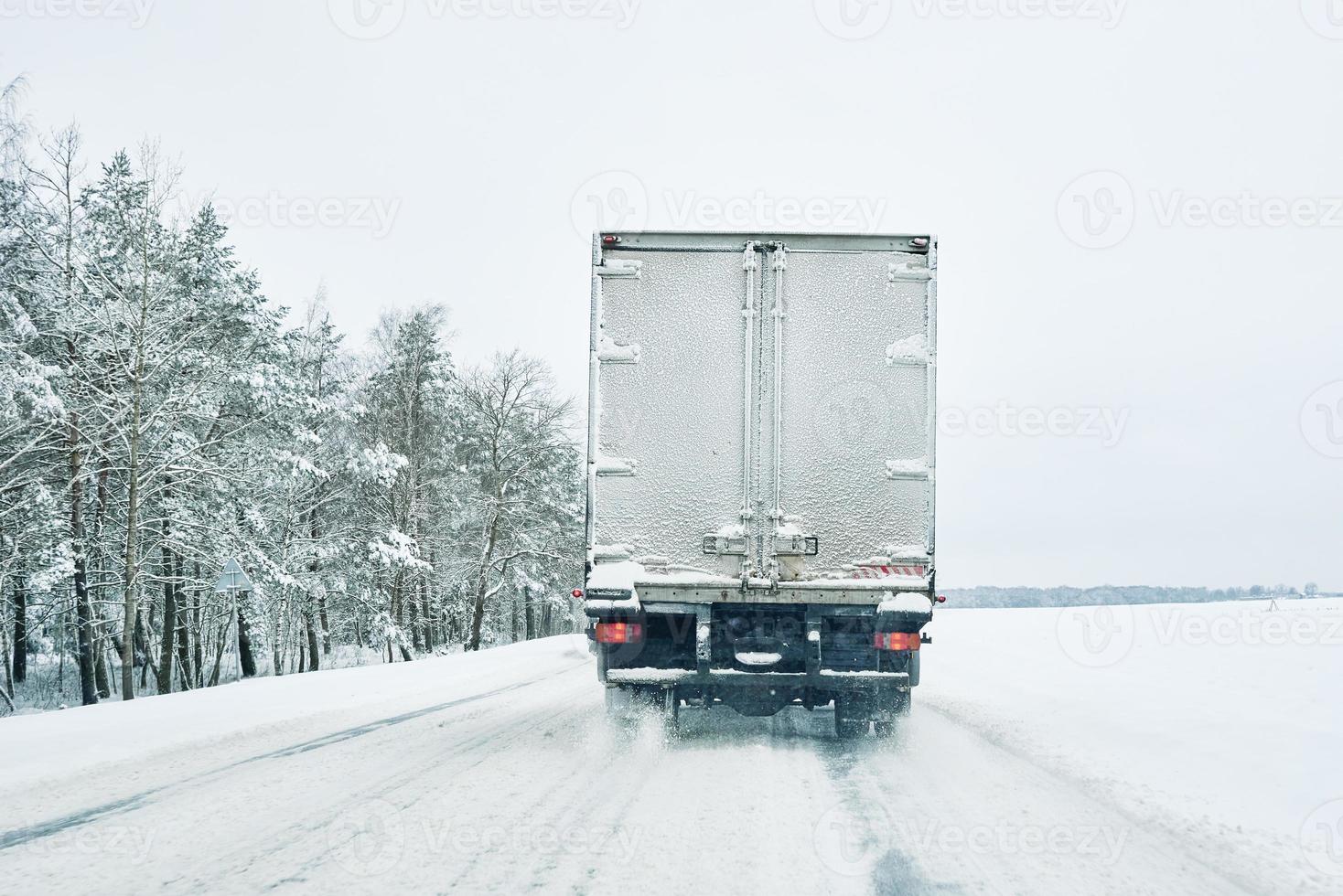 estrada de neve na floresta de inverno com carro em movimento foto