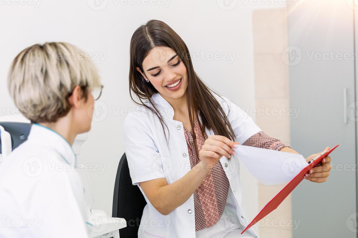 oftalmologista feminina mostrando os dados do paciente para uma prancheta, trabalhando em uma ótica. consultoria de médicos de conceito de saúde e medicina foto