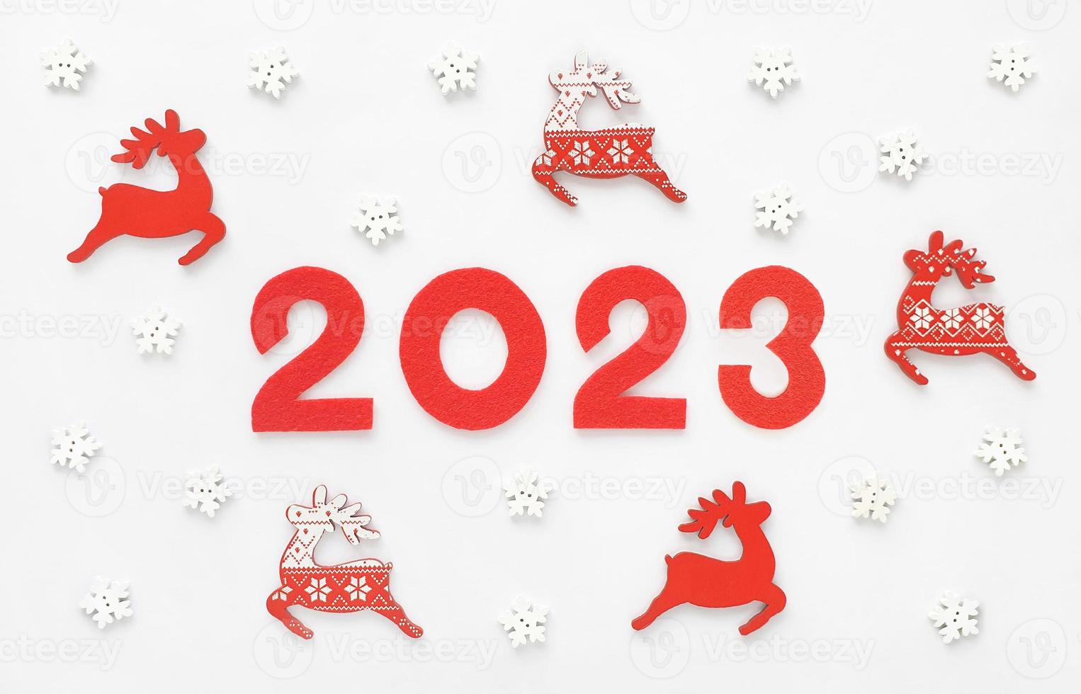 cartão de ano novo 2023 com renas de Papai Noel vermelhas e flocos de neve brancos. decorações de madeira e números de ano de feltro 2 0 2 3. foto