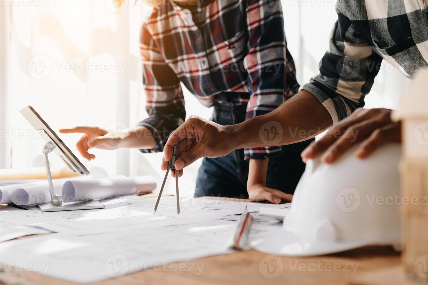 arquiteto criativo projetando grandes desenhos no escritório escuro do loft ou no café à luz da manhã foto