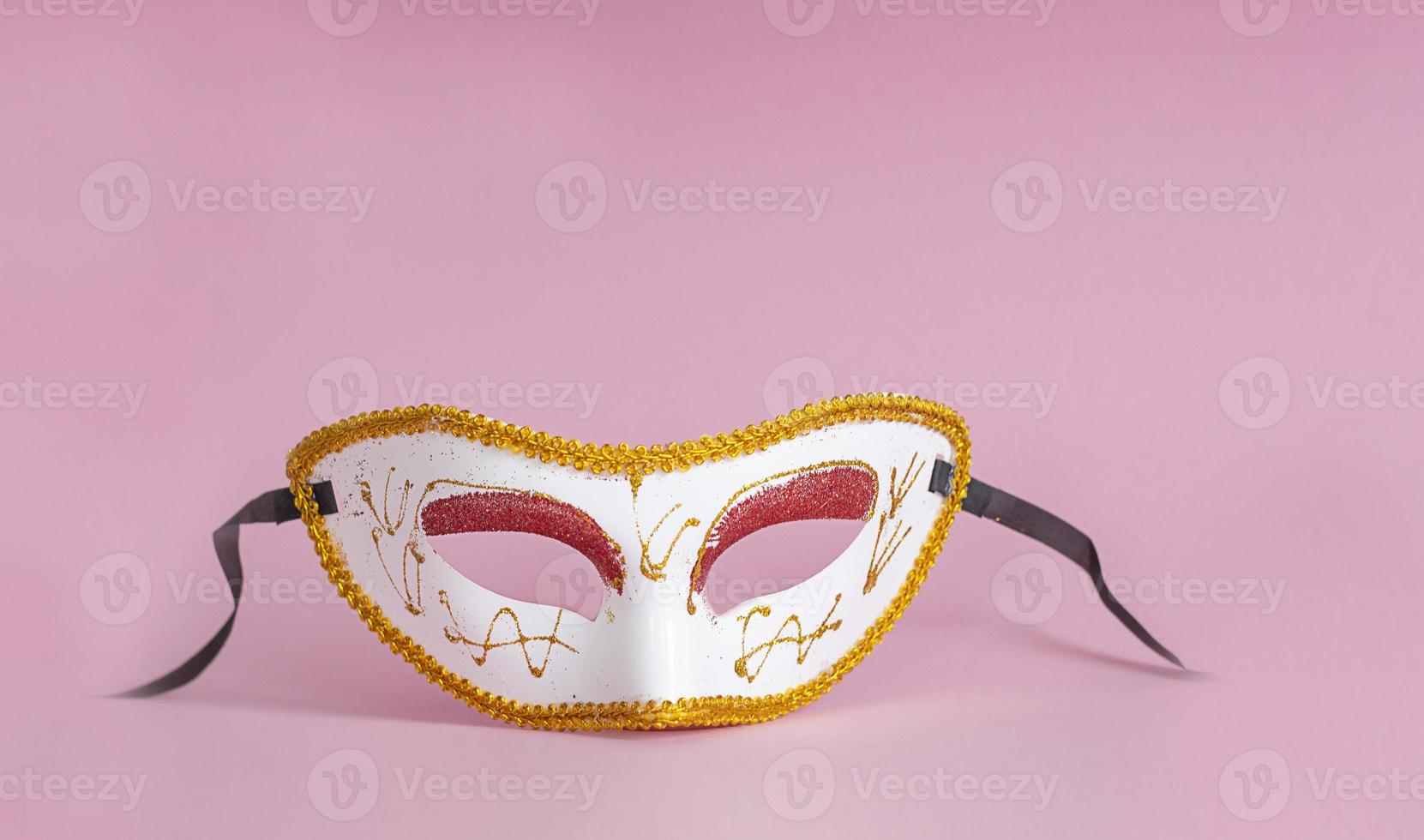carnaval. máscara facial festiva em um fundo rosa. fundo de carnaval mardi gras com máscaras de carnaval. foto