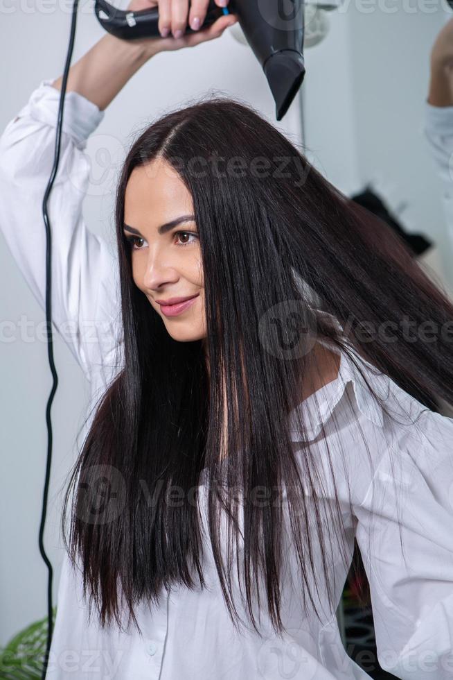 mulher jovem e bonita usando secador de cabelo no salão de cabeleireiro.  close-up do cabelo da mulher no salão de beleza, conceito de penteado  19576795 Foto de stock no Vecteezy