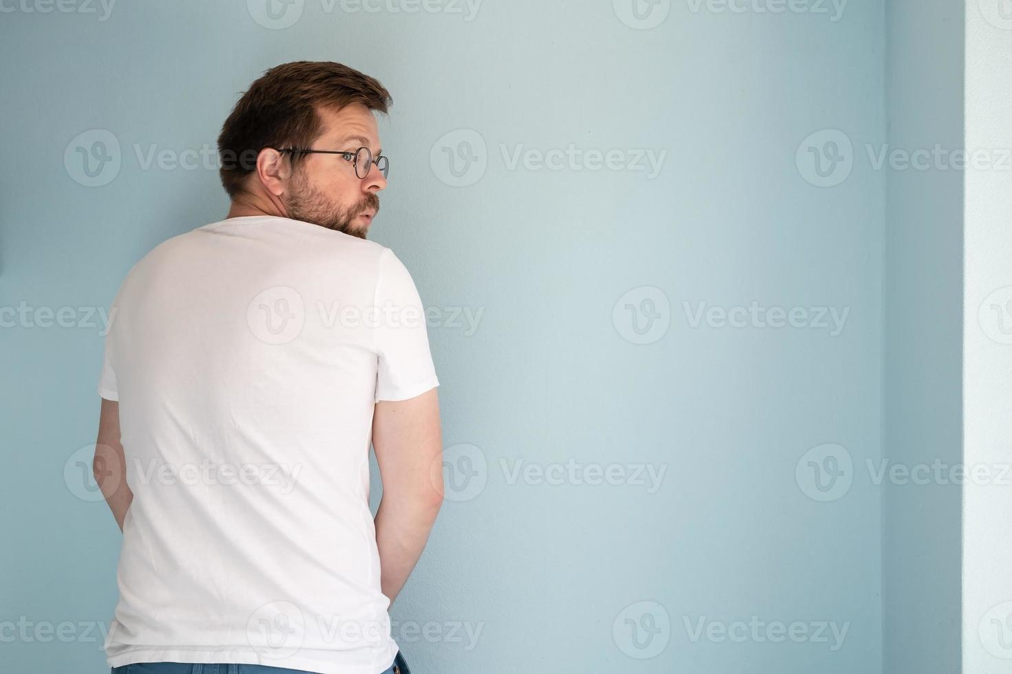 homem sem vergonha urinando na parede da casa ou se masturba, olhando em volta com medo e surpresa. copie o espaço. foto