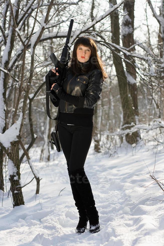 mulher com um rifle na floresta de inverno foto