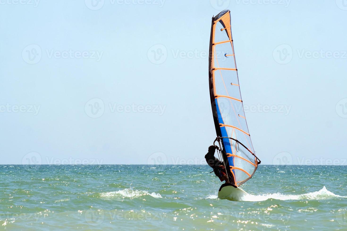 windsurfista na superfície do mar foto