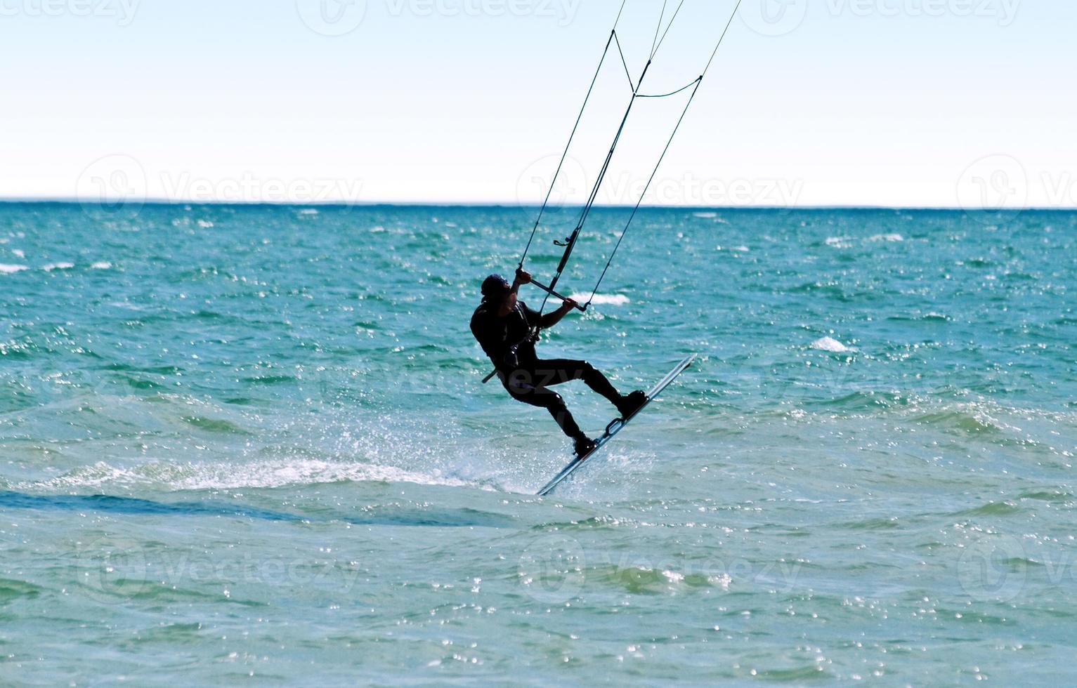 silhueta de um kitesurfista nas ondas do mar foto