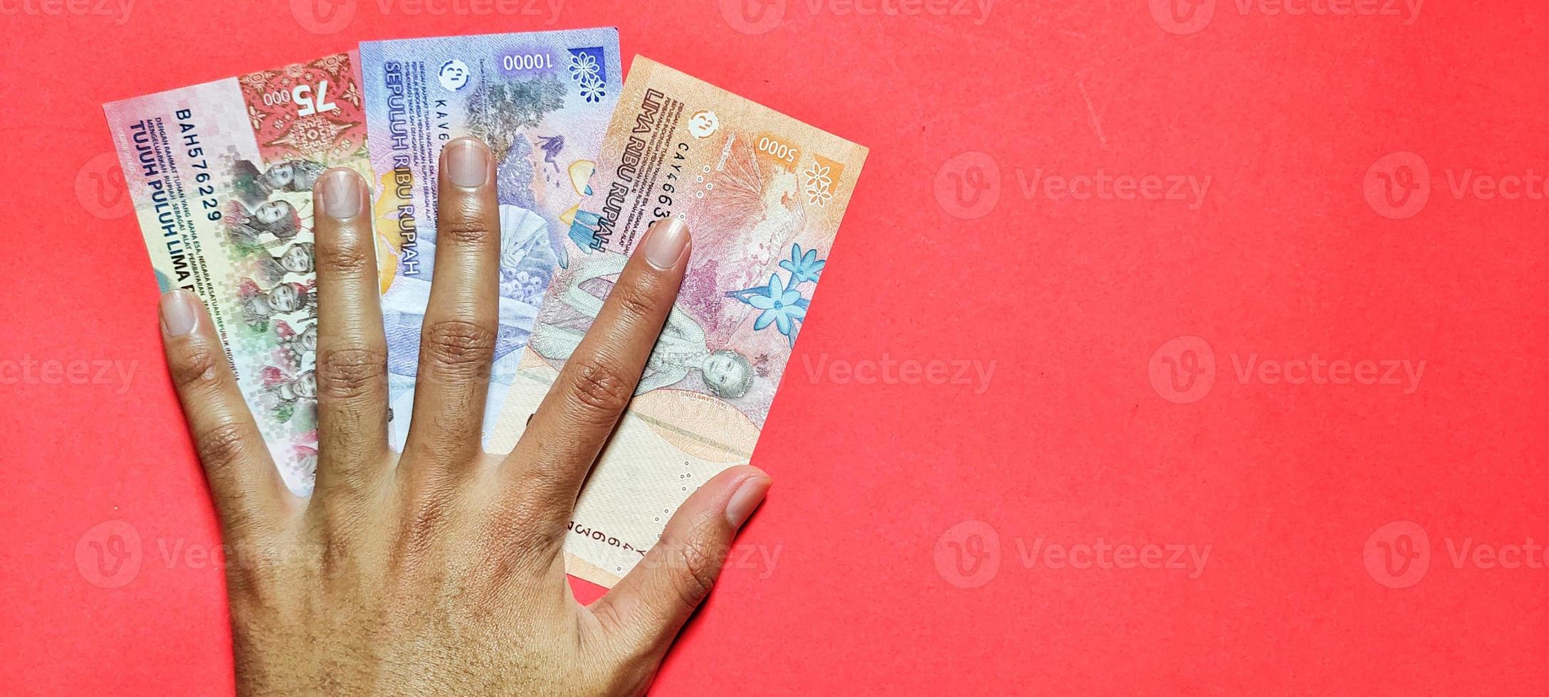 homem segurando dinheiro novo rupiah indonésia edição mais recente. foto