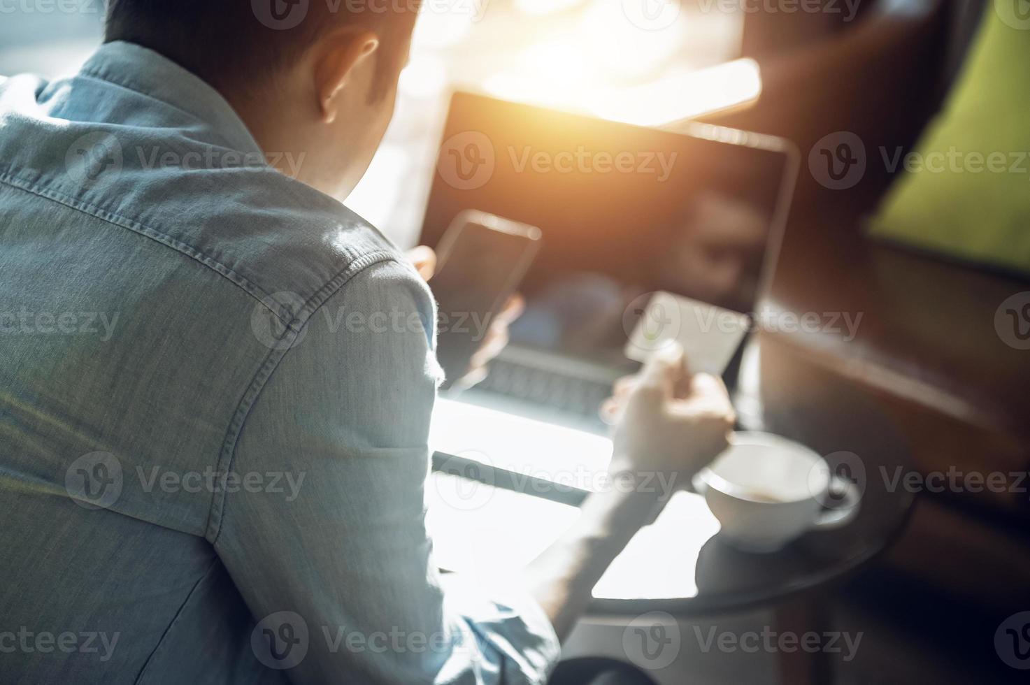 jovem asiático segurando o cartão de crédito e usando o pagamento on-line do laptop, conceito de compras on-line com cartão de crédito no café foto