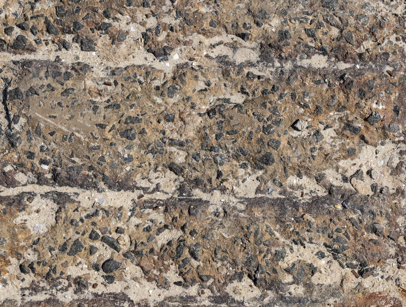 fragmento de textura de cimento com pequenas pedras de granito preto foto
