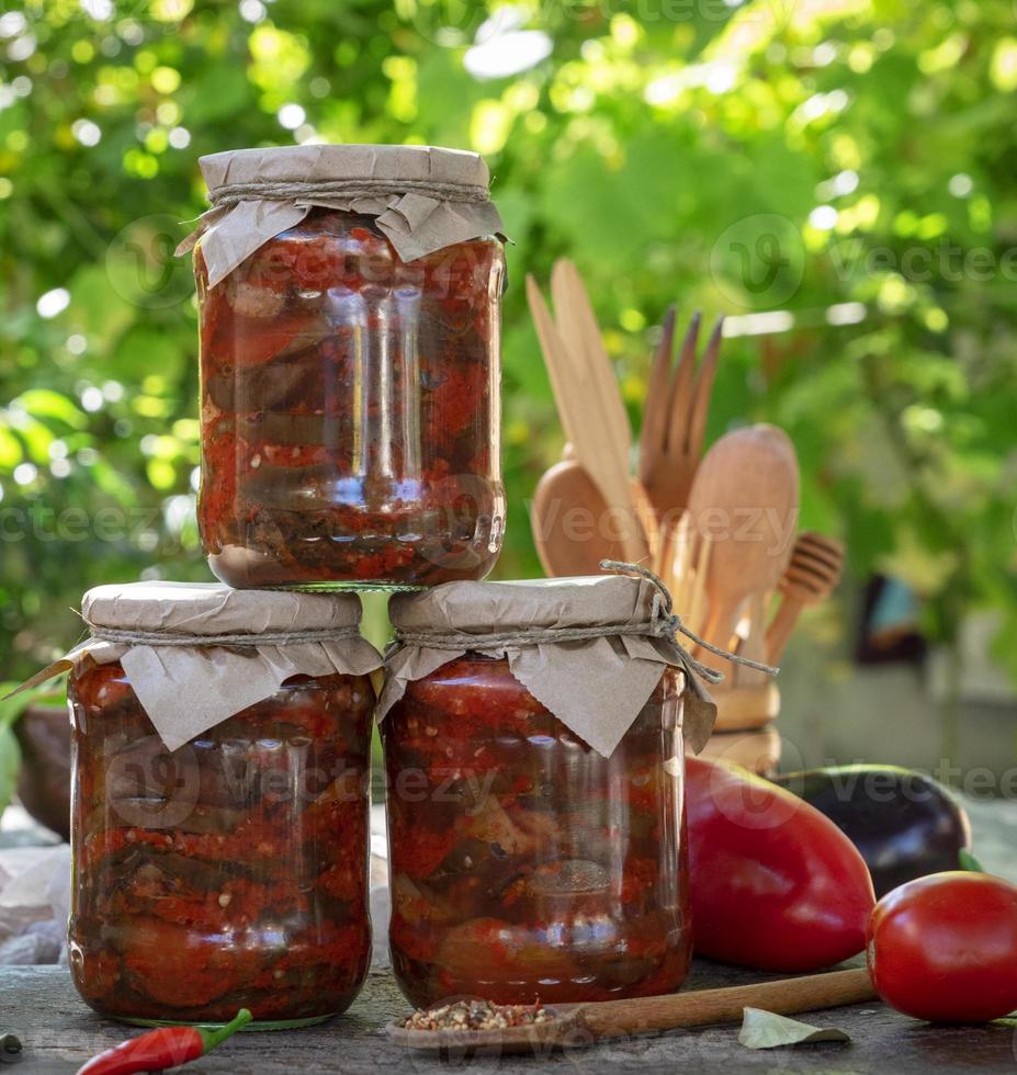 potes com pedaços enrolados de berinjela marinada em molho de legumes foto