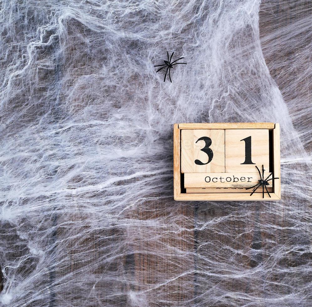 teia de aranha branca e calendário retrô de madeira feito de blocos com a data de 31 de outubro foto