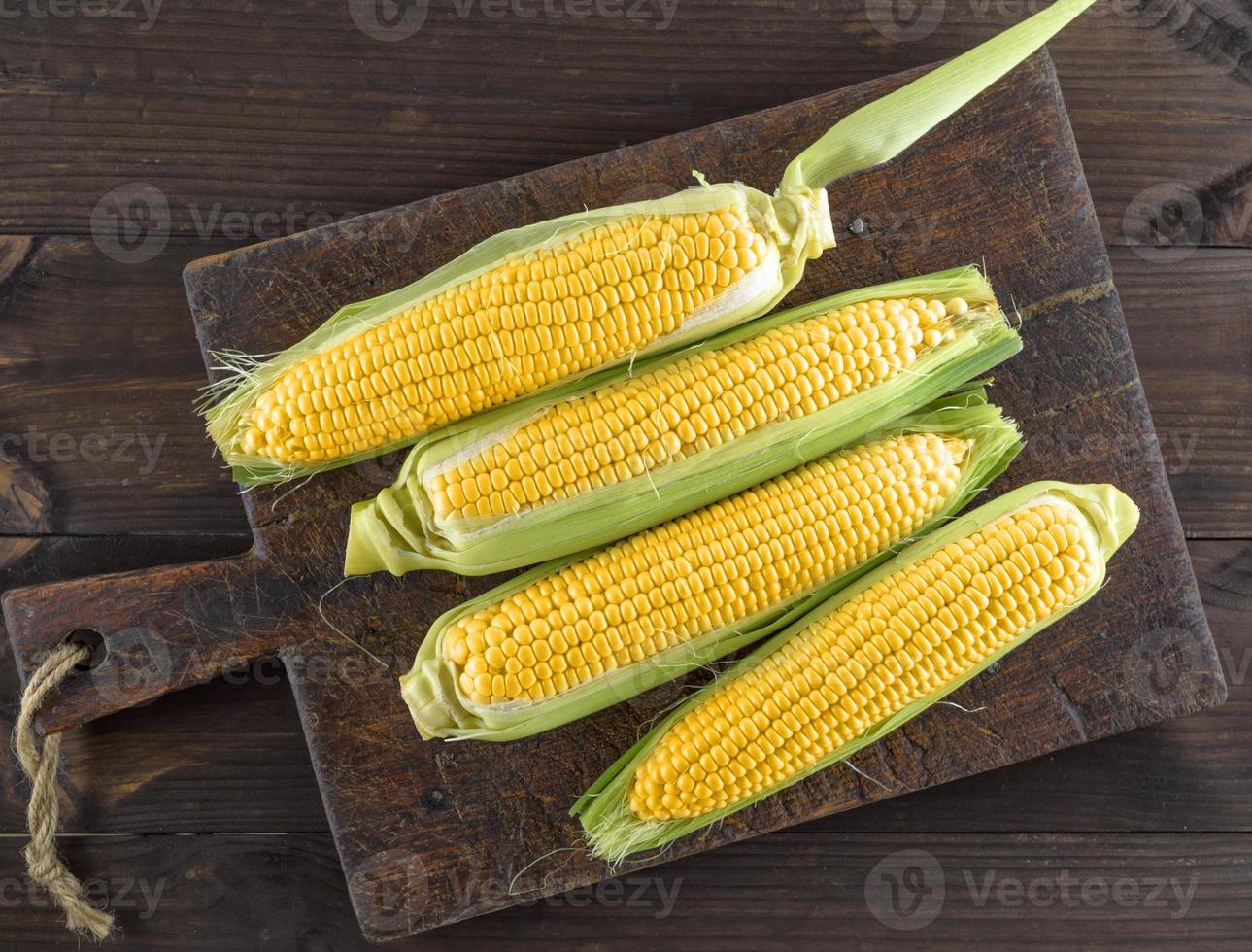 espigas de milho em uma velha placa de cozinha marrom foto