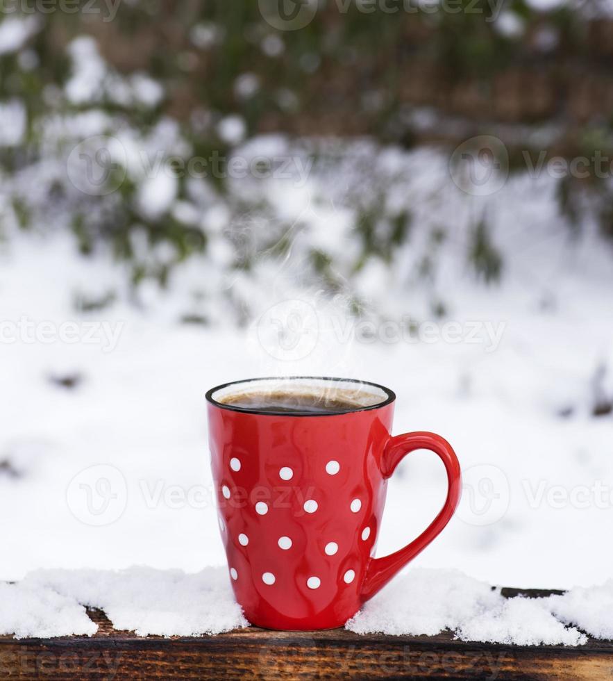 caneca de cerâmica vermelha em bolinhas brancas com café foto