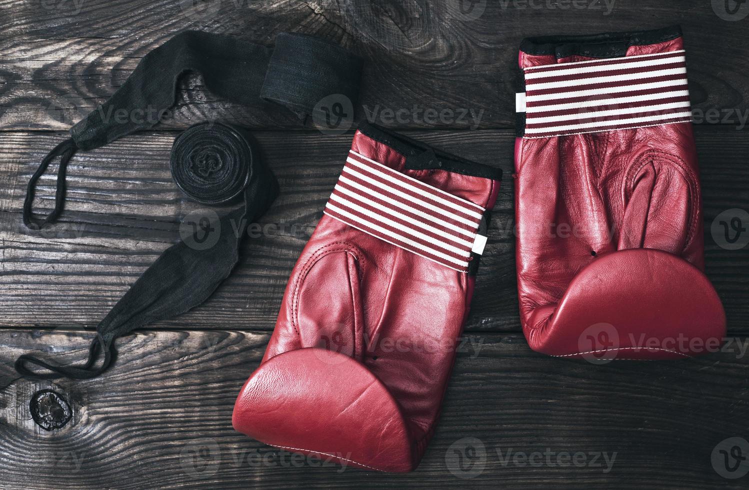 luvas de boxe de couro vermelho e uma bandagem elástica preta foto