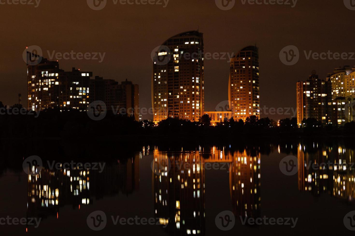 cidade noturna com reflexo de casas no rio foto