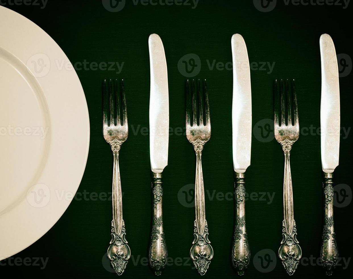 pratos brancos meio vazios, garfo e faca vintage foto