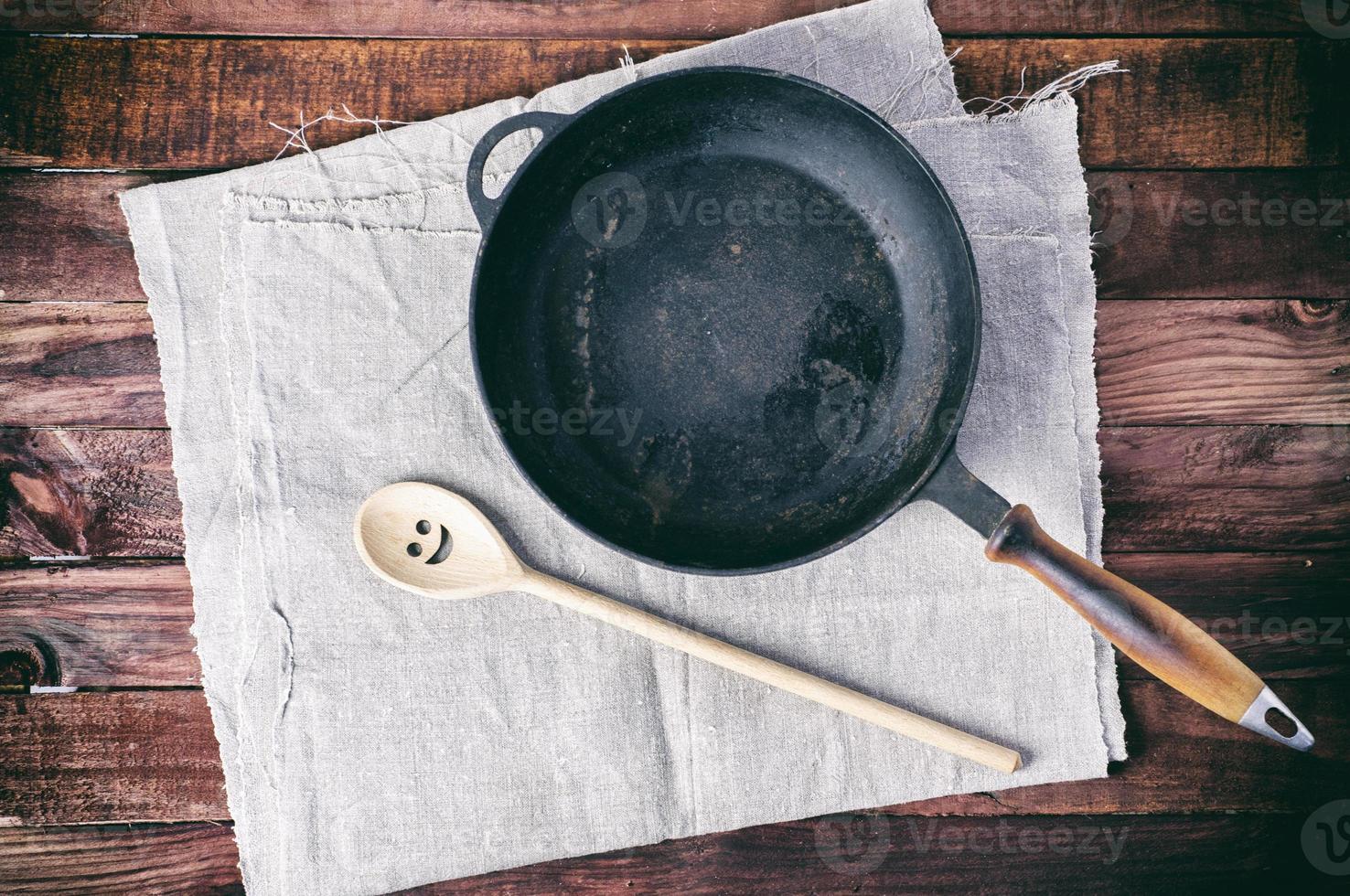 panela de ferro fundido com uma espátula em um guardanapo têxtil cinza foto