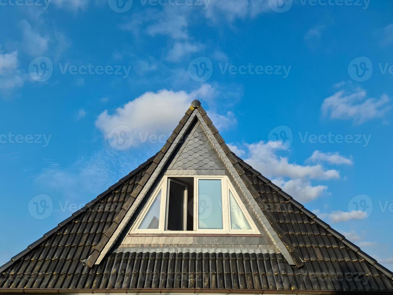 janela de telhado aberta em estilo velux com telhas pretas. foto