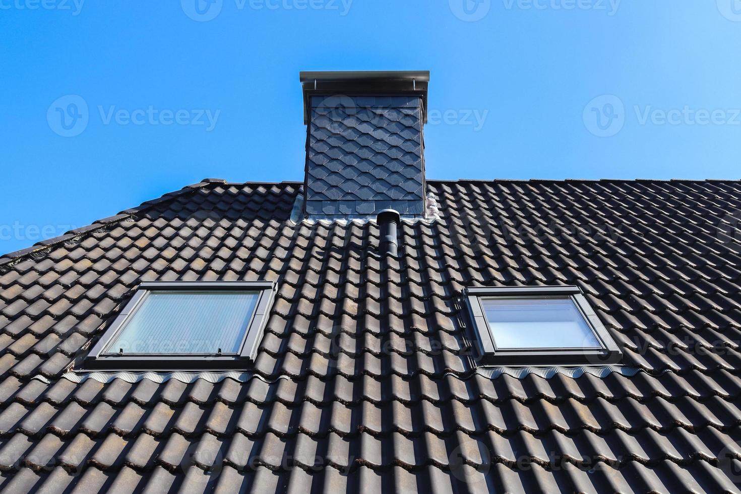 janela de telhado em estilo velux com telhas pretas. foto